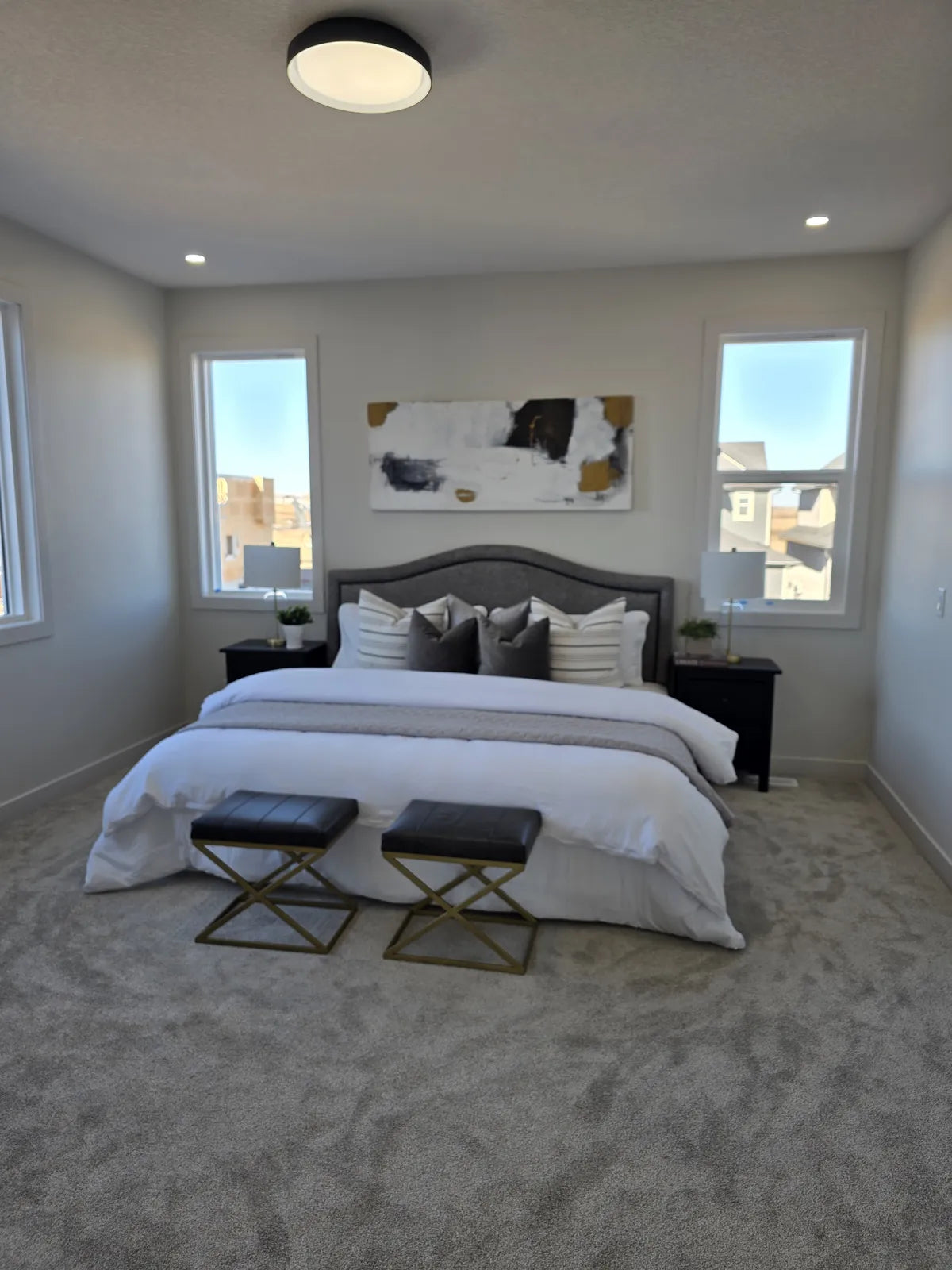 Bedroom styled with a grey tufted headboard and bench
