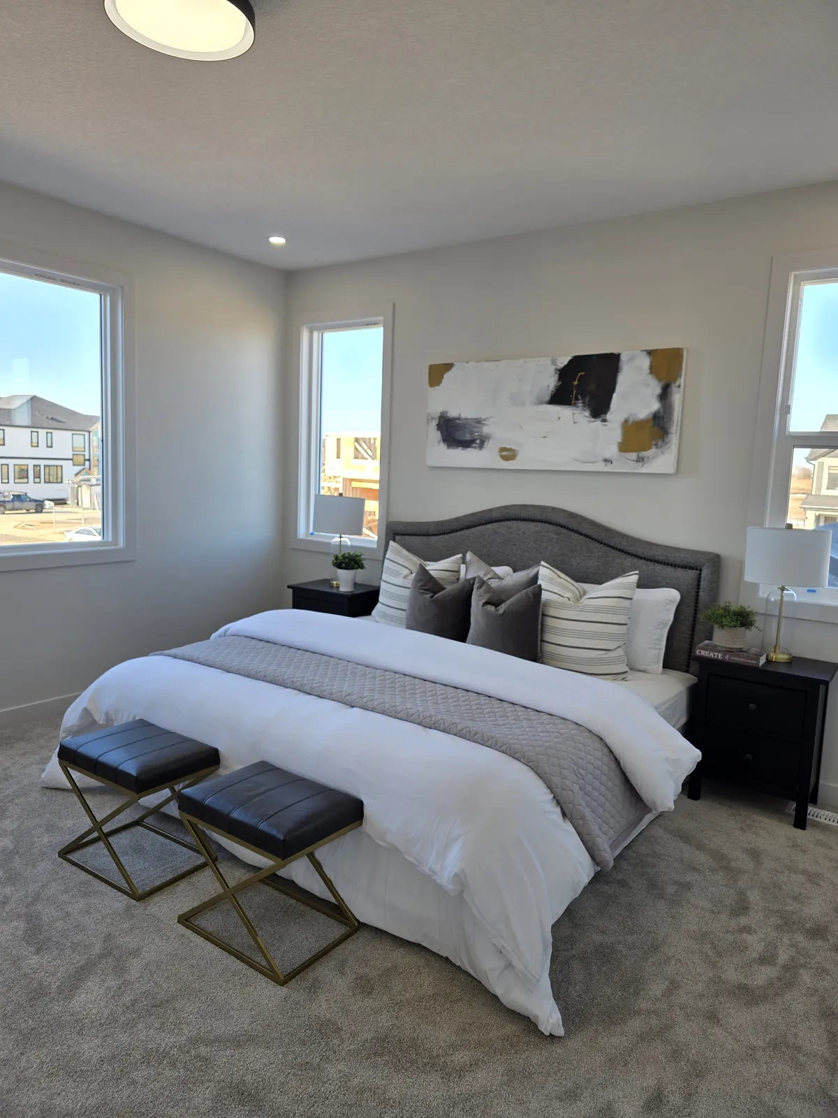 Bedroom styled with a tufted headboard and folded throw