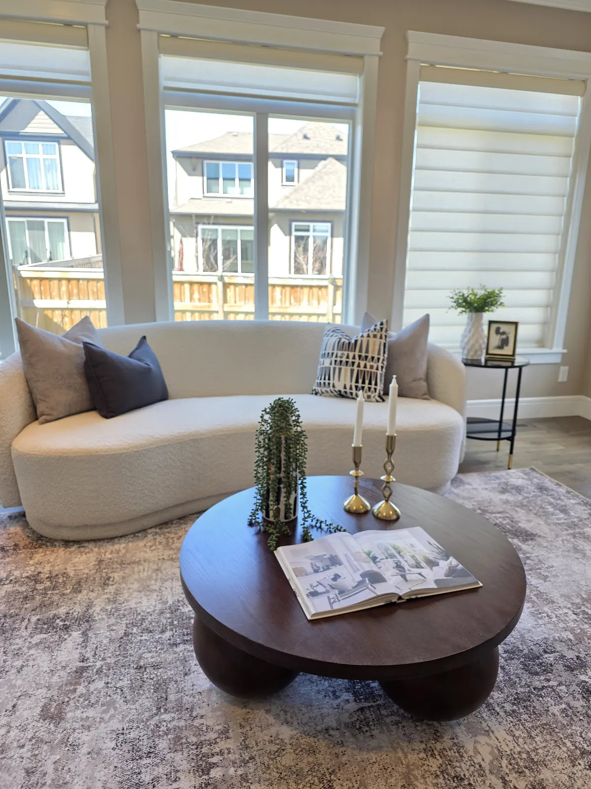 Living room staged with a cream sofa beside a bay window