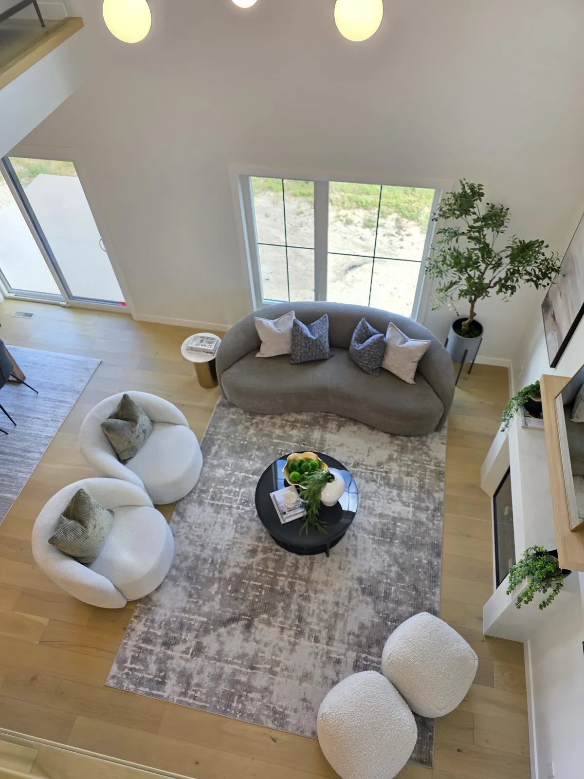 Vaulted living room staged with grey sofa and round poufs