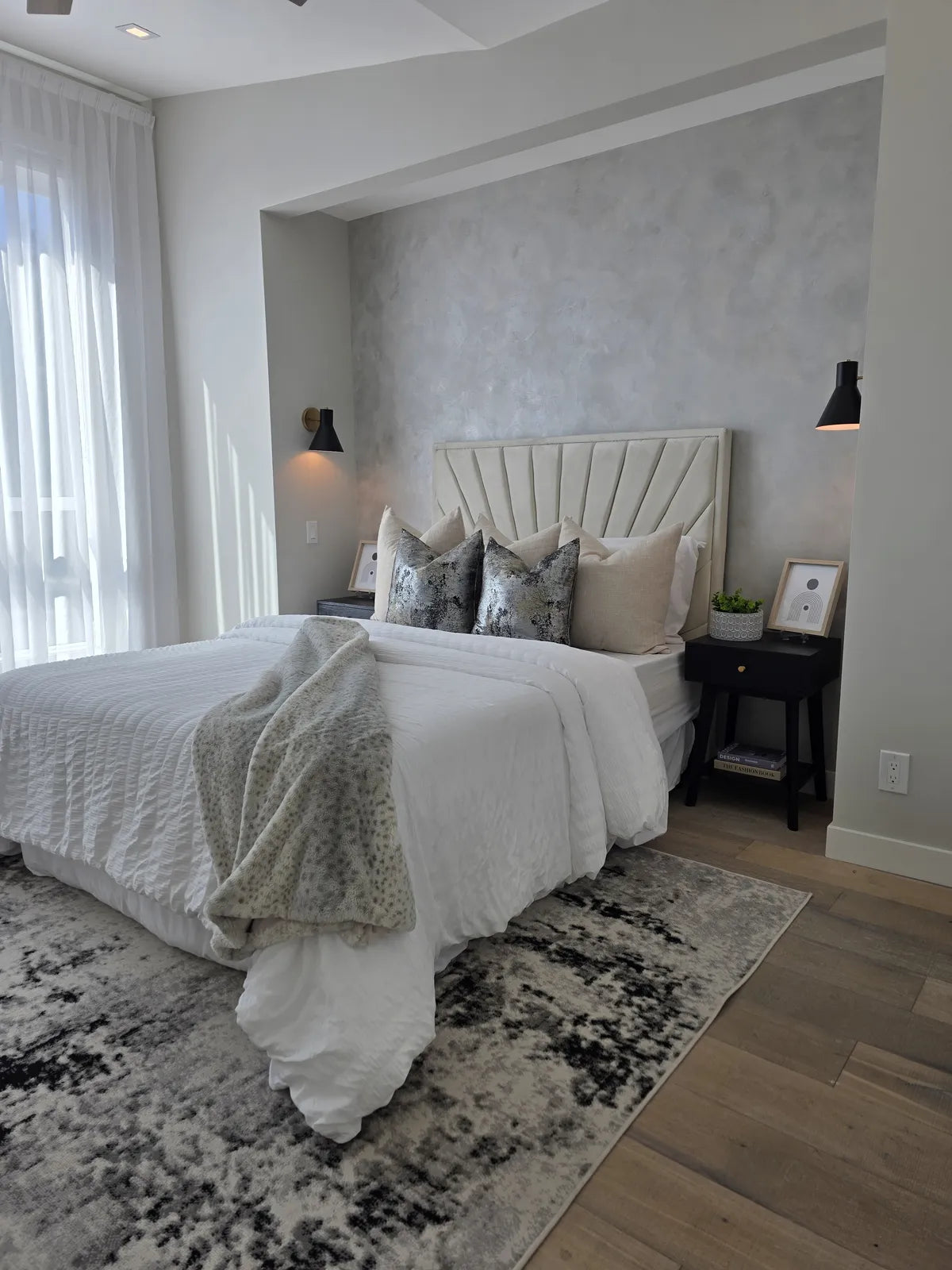 Bedroom styled with a white bed and patterned wallpaper, alternate angle