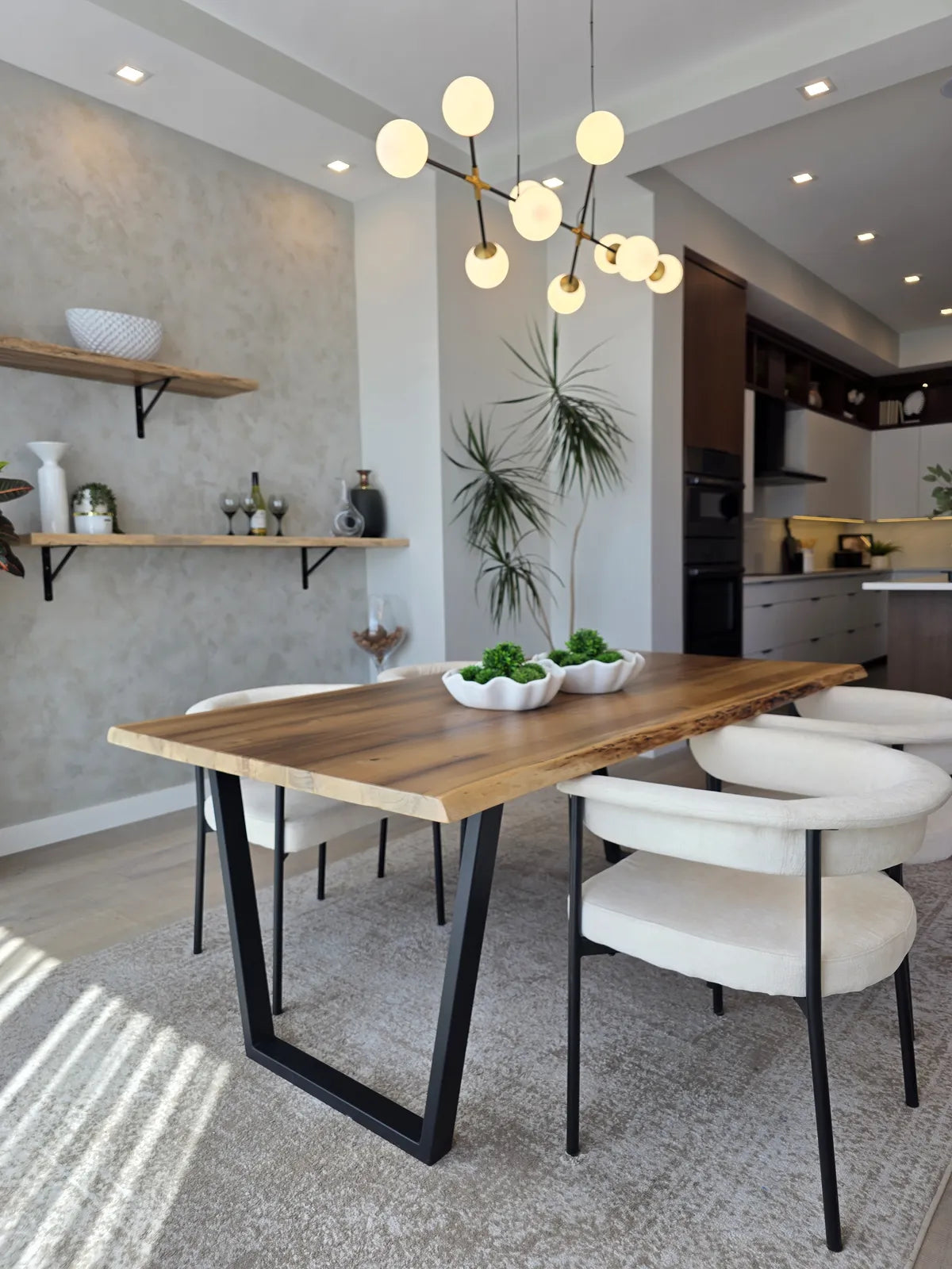 Dining room with a wood table, white chairs and pendant lighting