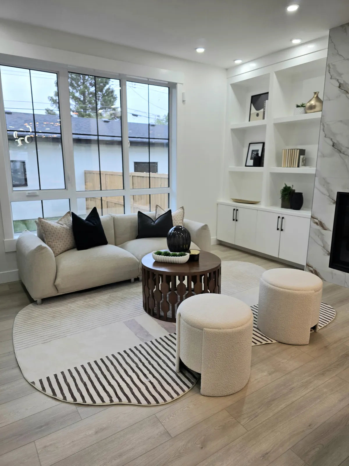 Light-filled living room staged with a sofa and window seating