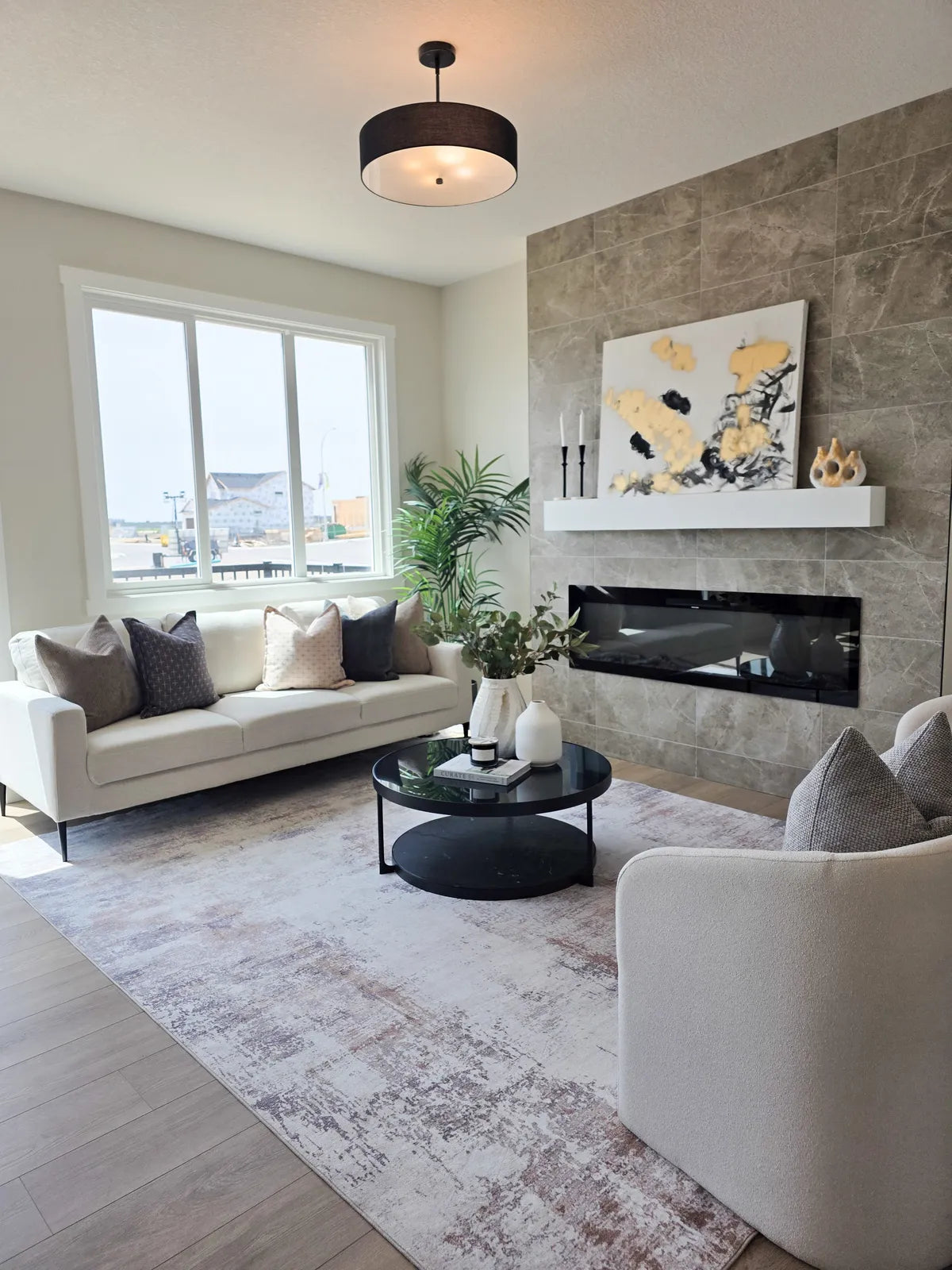 Living room staged around a fireplace with a cream sofa and plant