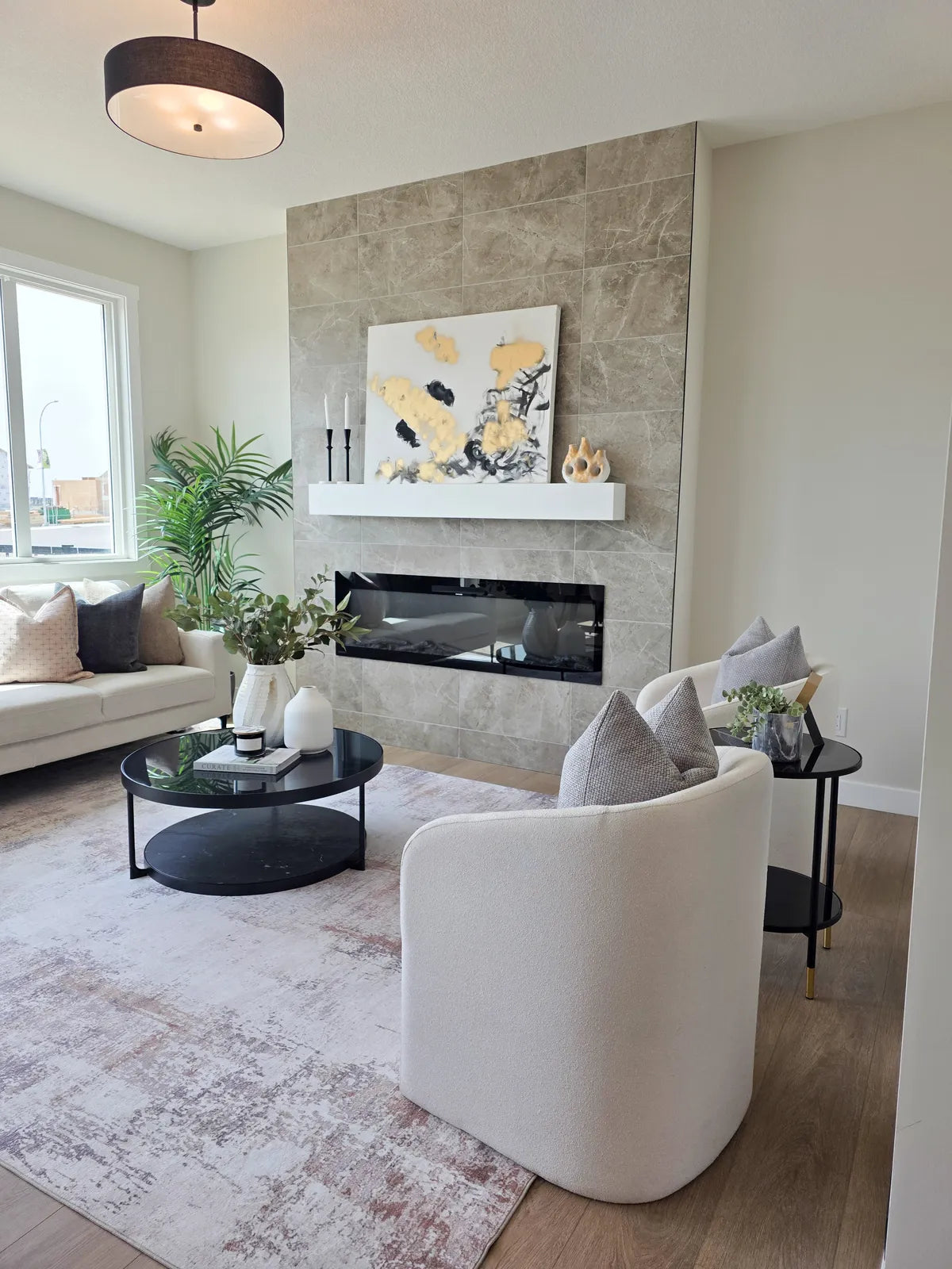 Living room staged around a fireplace with round accent seating
