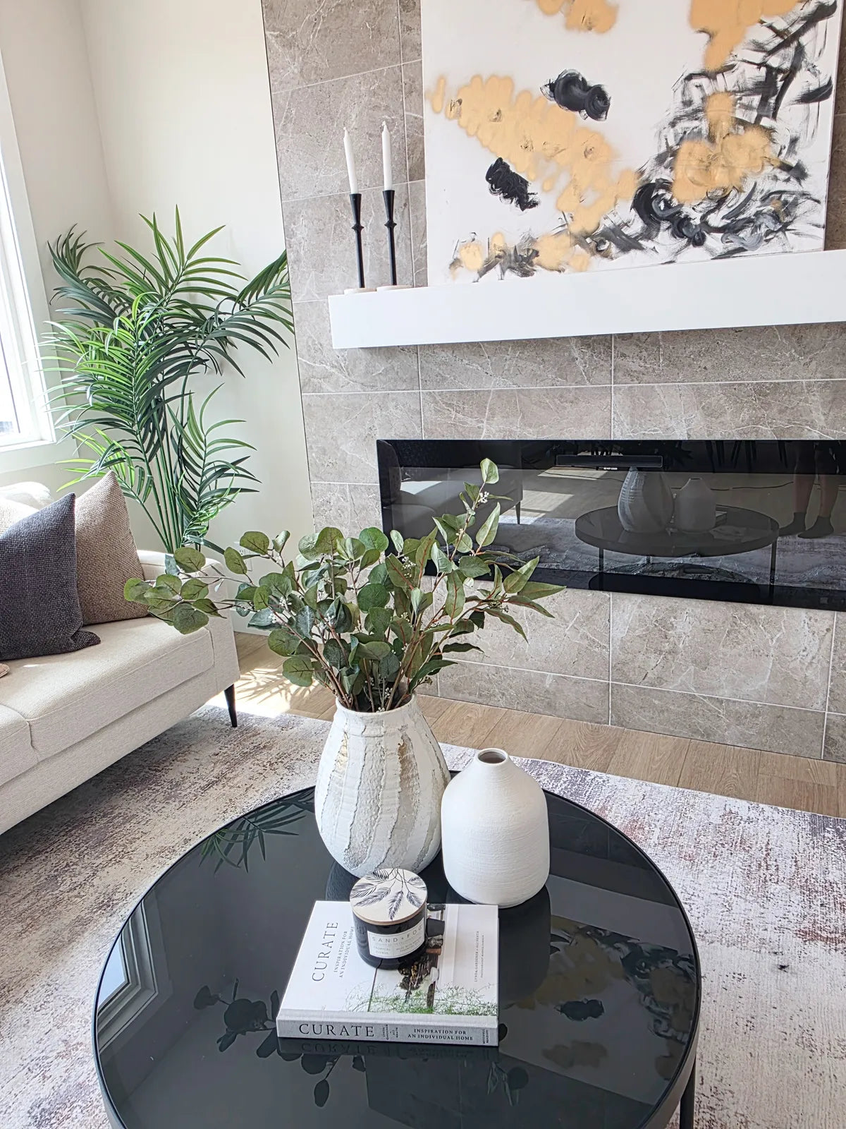 Living room staged around a fireplace with a round coffee table