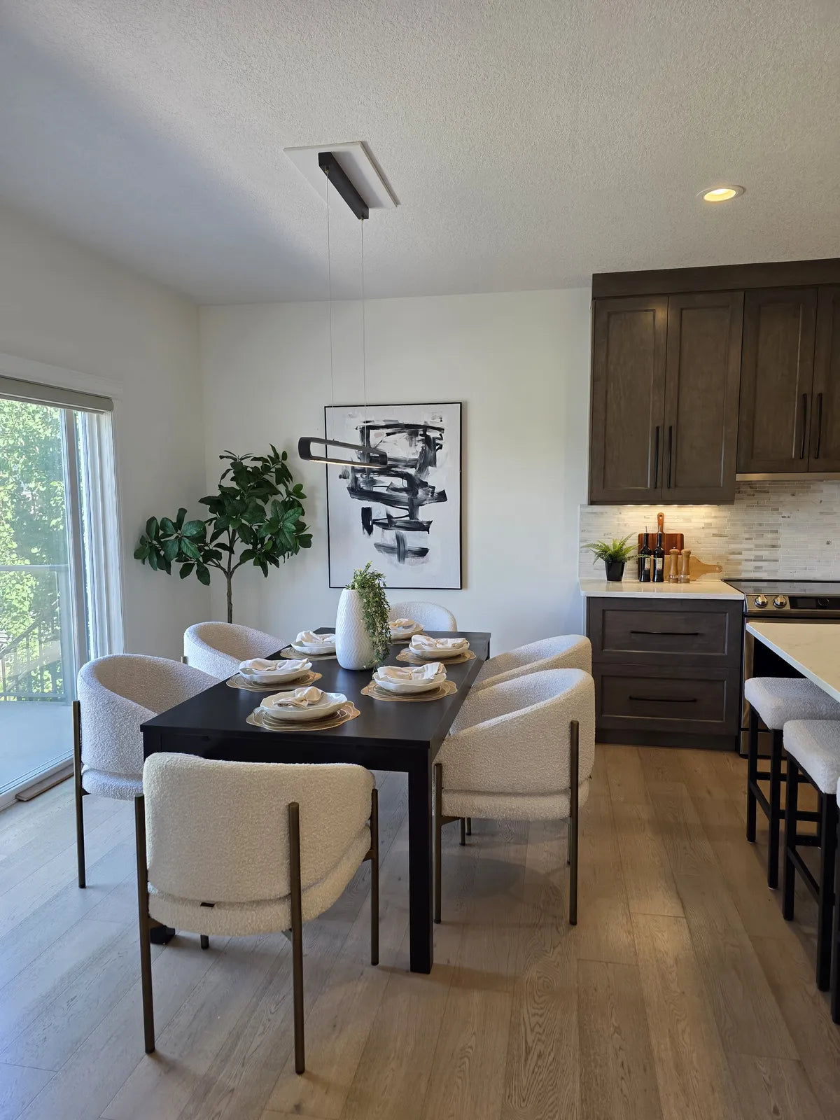 Kitchen with dark cabinetry and a dining table