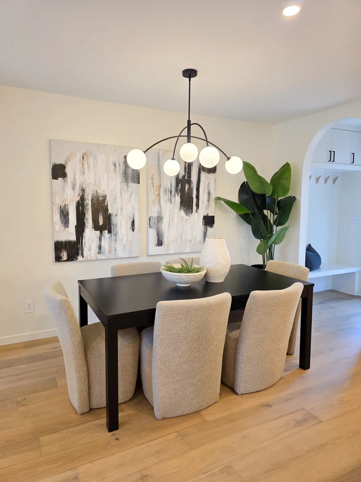 Dining room with black chairs and a statement plant