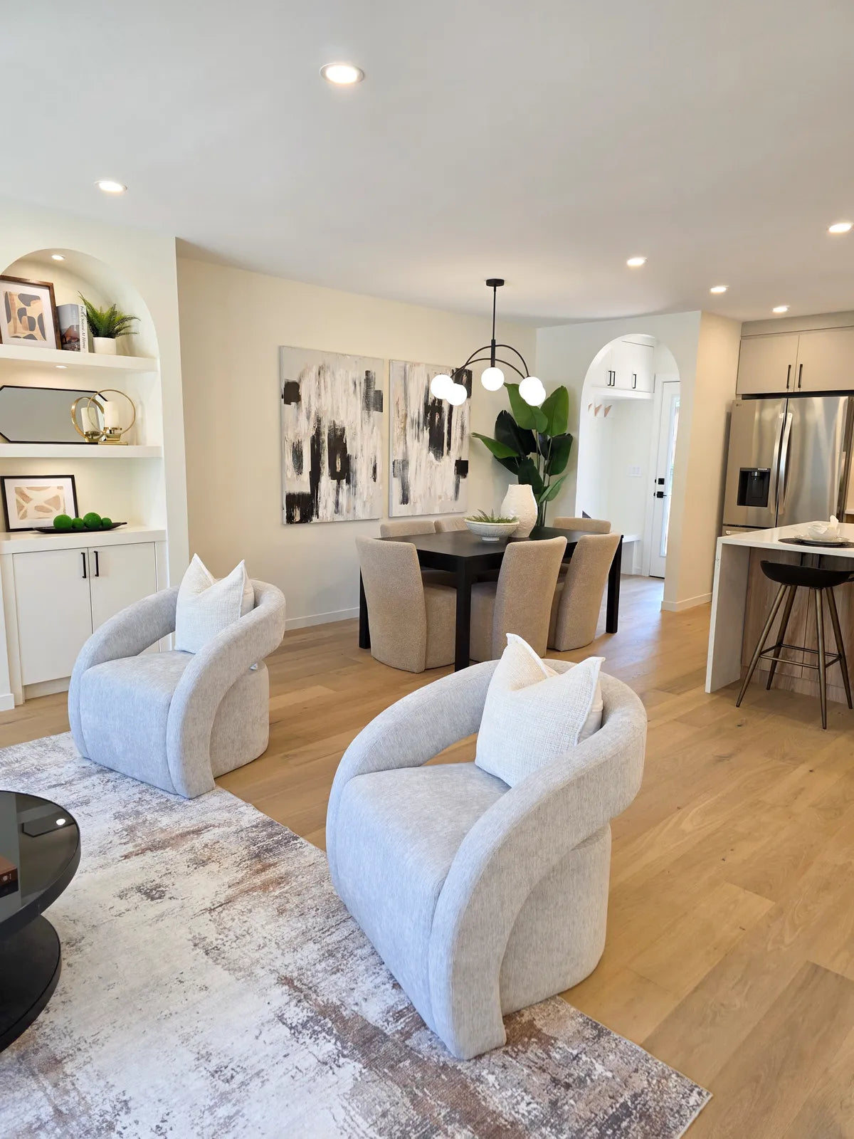 Living room staged with cream accent chairs and a plant