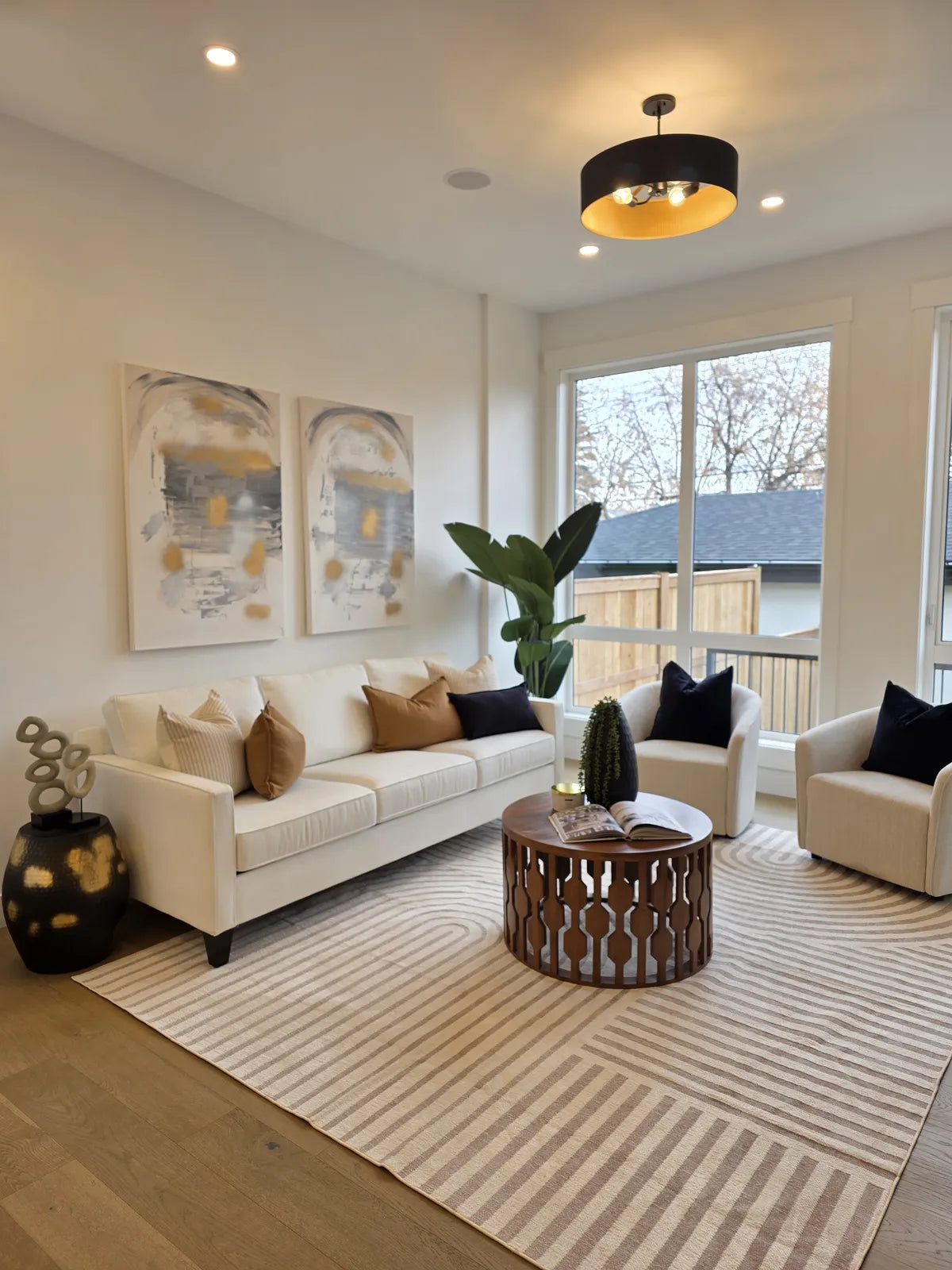 Living room staged with a cream sofa and striped area rug