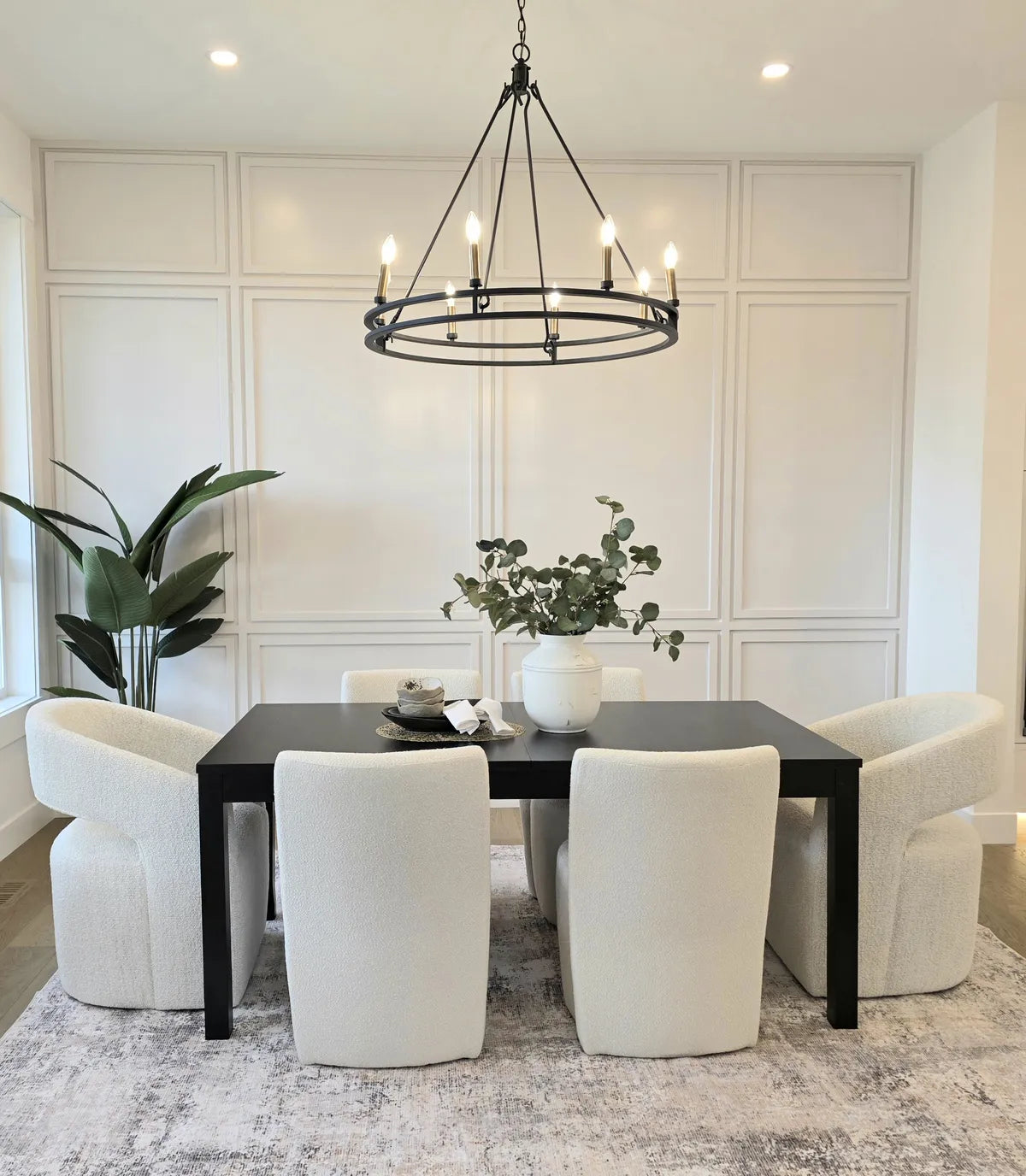 Dining room with a round table, black chairs and chandelier